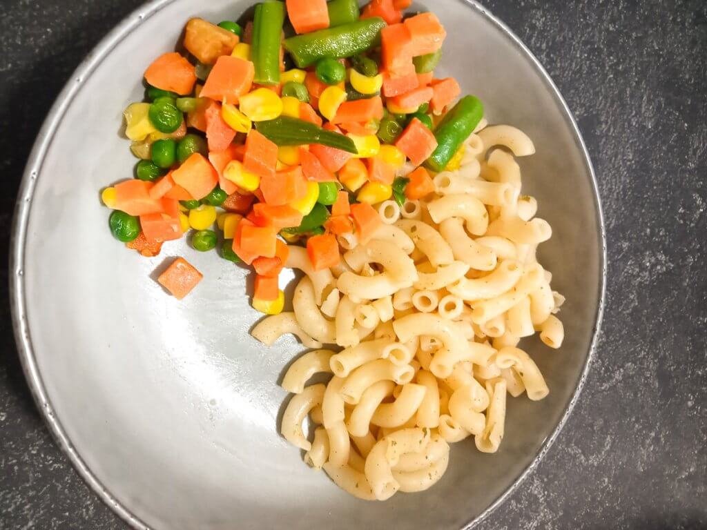 cooked pasta and cooked veggies in a bowl.