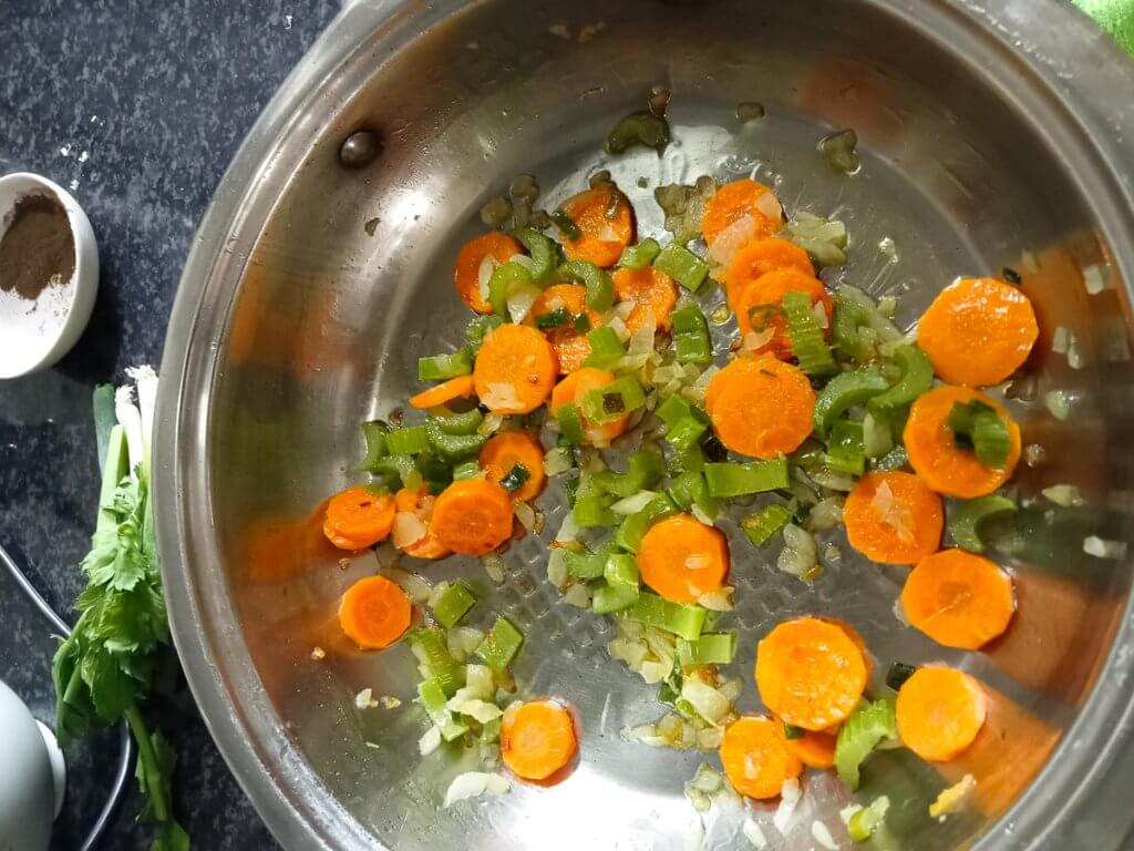 onions, celery, and carrots in a frying pan.