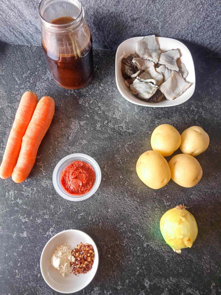 Ingredients photo- broth, tripe, carrots, potatoes, tomato paste, onion, chili flakes, and garlic powder.