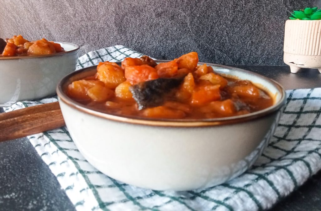 close-up image of Campbell pepper pot soup in a bowl on top of a tablecloth.