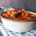 close-up image of Campbell pepper pot soup in a bowl on top of a tablecloth.
