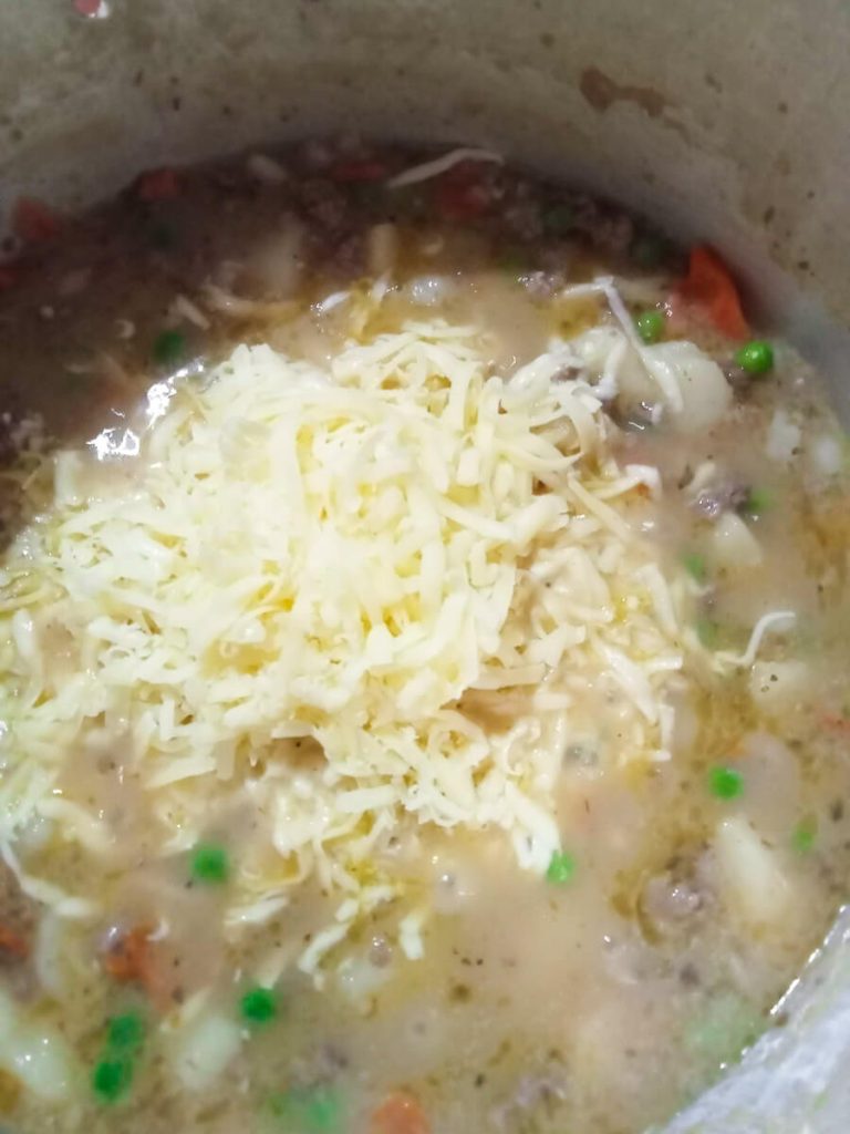 Process photo- adding shredded cheese to the soup