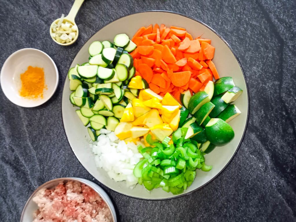 chopped vegetables on a plate with a black background.