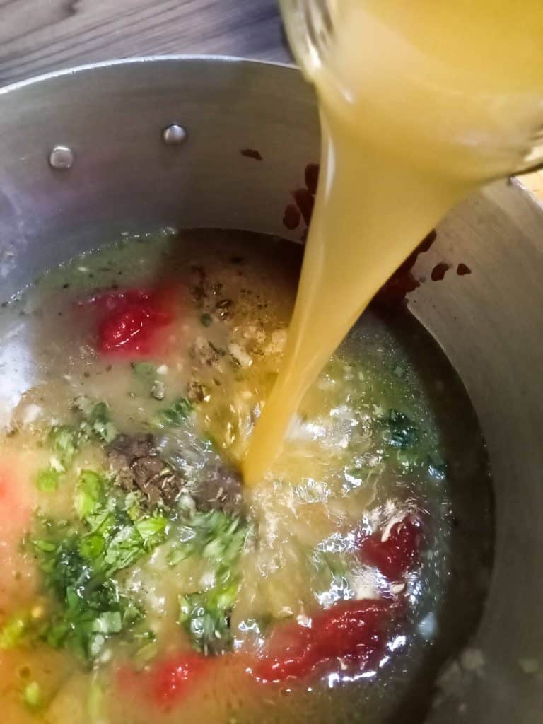 beef broth added to a pot of fried vegetables