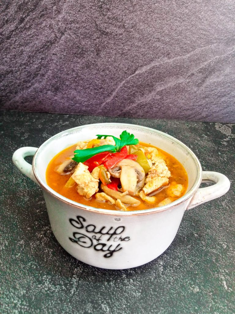 a bowl of stir fry soup on a black background.