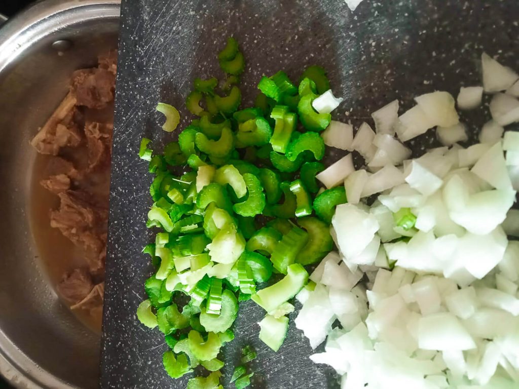 Process photo: adding chopped celery and onion to the beef and broccoli soup pot.