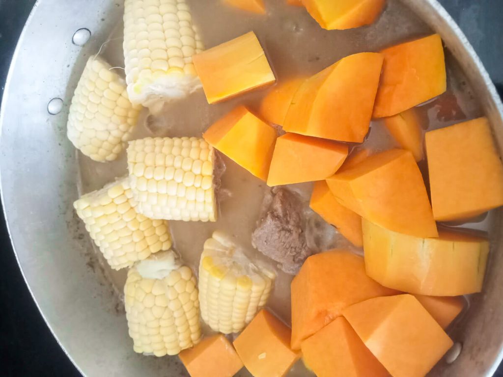 Jamaican red peas soup process photo: adding sweet corn and butternut squash.