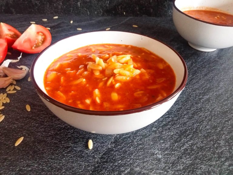 two bowls of tomato and pasta soup inspired by a Mexican star soup recipe with leftover ingredients beside it.