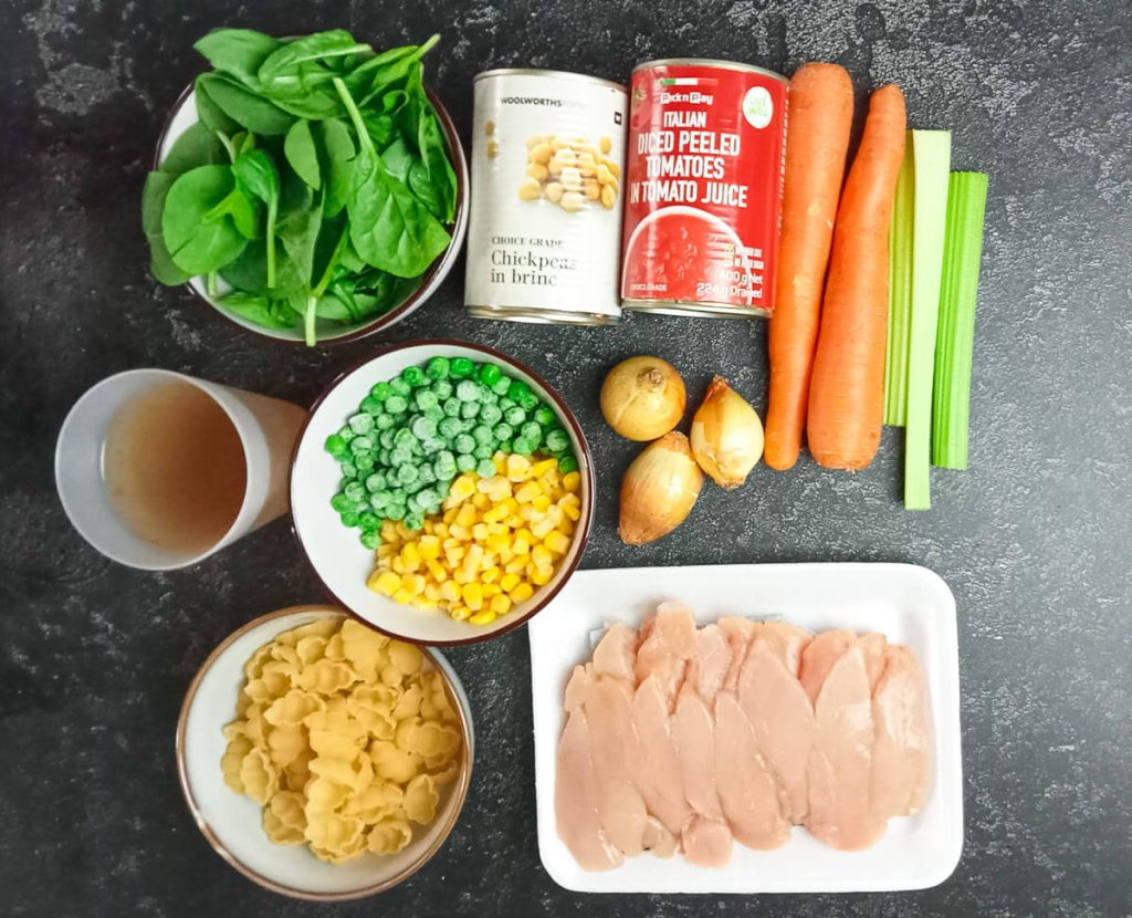 ingredients image: Spinach, chickpeas, canned tomatoes, carrots, celery, onion, sweet corn, green peas, chicken breast, pasta, and chicken broth.