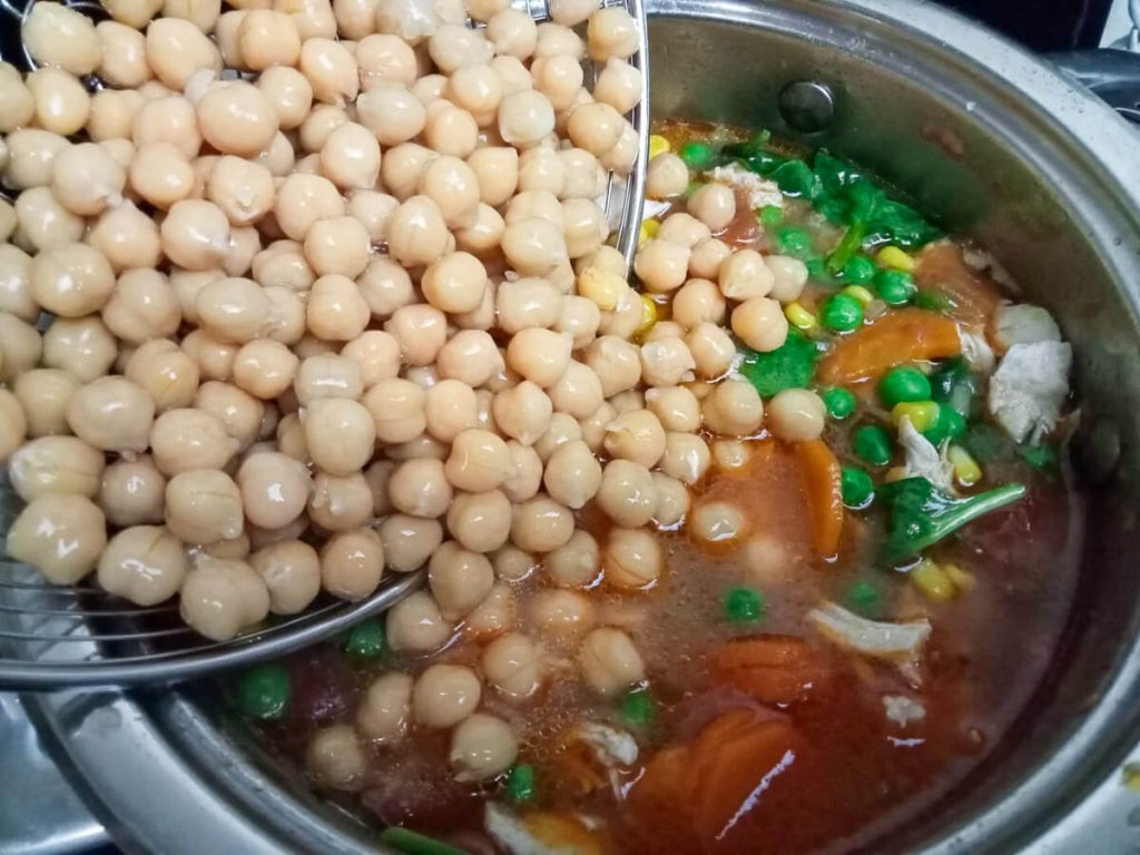 process image: Adding chickpeas into the pot of soup