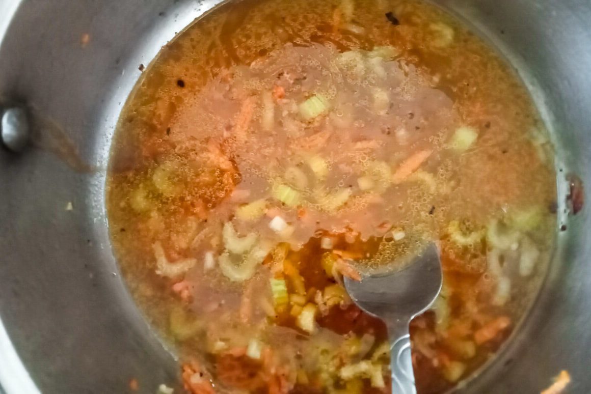 Process image: adding chicken broth to the pot