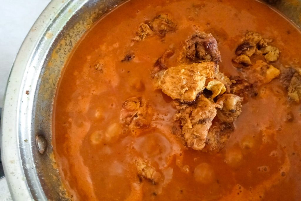 Process image: adding browned chicken to the pot of gravy