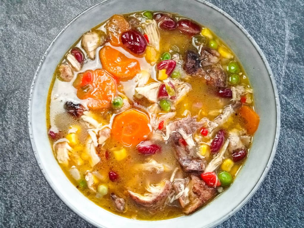 a bowl of jerk chicken soup o a black background