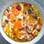 a bowl of jerk chicken soup o a black background