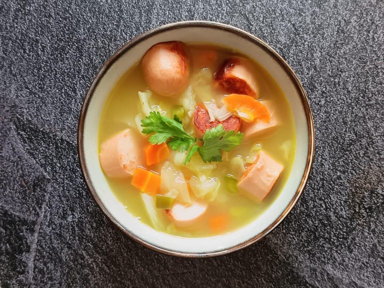 A bowl of Irish cabbage soup on a black background.